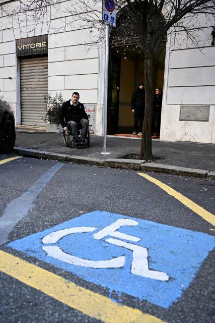 Italian lawyer Alessandro Bardini looks at a parking space reserved for people with disabilities in Rome, on February 25, 2026. Paralympic organisers and Italy's government have invested tens of millions of euros in making the venues and areas around the Milan-Cortina Paralympic Games more accessible for people with disabilities. But the story is not the same across Italy, particularly in the capital Rome, known as much for its uneven roads and anarchic parking as for its ancient ruins. (Photo by Filippo MONTEFORTE / AFP)