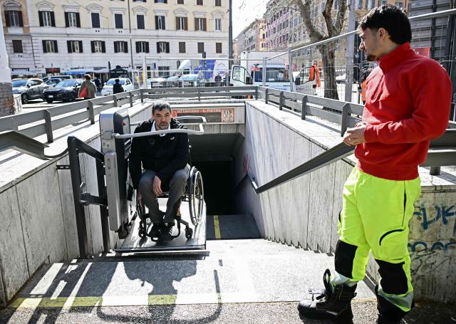 Italian lawyer Alessandro Bardin uses a stair lift to leave a metro station in Rome on February 25, 2026. Paralympic organisers and Italy's government have invested tens of millions of euros in making the venues and areas around the Milan-Cortina Paralympic Games more accessible for people with disabilities. But the story is not the same across Italy, particularly in the capital Rome, known as much for its uneven roads and anarchic parking as for its ancient ruins. (Photo by Filippo MONTEFORTE / AFP)
