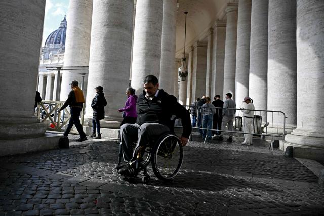 Italian lawyer Alessandro Bardin makes its way on his wheelchair past the colonnade of St. Peter's Square, in Rome on February 25, 2026. Paralympic organisers and Italy's government have invested tens of millions of euros in making the venues and areas around the Milan-Cortina Paralympic Games more accessible for people with disabilities. But the story is not the same across Italy, particularly in the capital Rome, known as much for its uneven roads and anarchic parking as for its ancient ruins. (Photo by Filippo MONTEFORTE / AFP)