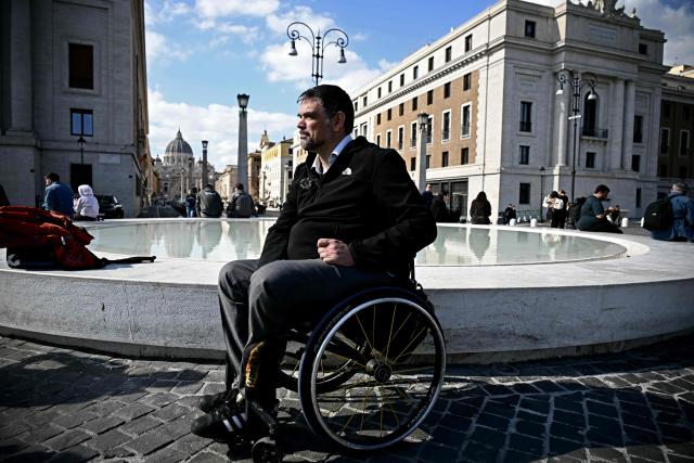 Italian lawyer Alessandro Bardin makes his way in his wheelchair across the newly redesigned Piazza Pia in Rome on February 25, 2026. Paralympic organisers and Italy's government have invested tens of millions of euros in making the venues and areas around the Milan-Cortina Paralympic Games more accessible for people with disabilities. But the story is not the same across Italy, particularly in the capital Rome, known as much for its uneven roads and anarchic parking as for its ancient ruins. (Photo by Filippo MONTEFORTE / AFP)