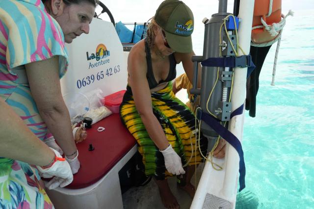 Aline Tribollet, research director at the French National Research Institute for Sustainable Development (IRD), and Sophie Bureau, assistant engineer in Ecology at the University of La Réunion, collect a water sample for a pH test, in the northern part of Mayotte Lagoon, on the French Indian Ocean territory of Mayotte, on February 24, 2026. Cyclone Chido struck Mayotte in December 2024, adding to the effects of a heatwave that had already weakened the reefs earlier that year. Coral mortality ranges from 26 to 88 percent depending on the site, according to the Mayotte Marine Nature Park. (Photo by Marine GACHET / AFP)