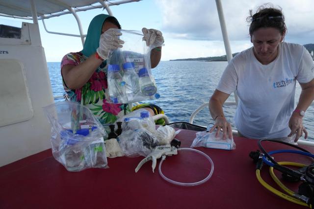 Anne Chauvin, research engineer at the French National Research Institute for Sustainable Development (IRD), and Aline Tribollet, research director at the IRD handle water samples, in the northern part of Mayotte Lagoon, on the French Indian Ocean territory of Mayotte, on February 24, 2026. Cyclone Chido struck Mayotte in December 2024, adding to the effects of a heatwave that had already weakened the reefs earlier that year. Coral mortality ranges from 26 to 88 percent depending on the site, according to the Mayotte Marine Nature Park. (Photo by Marine GACHET / AFP)