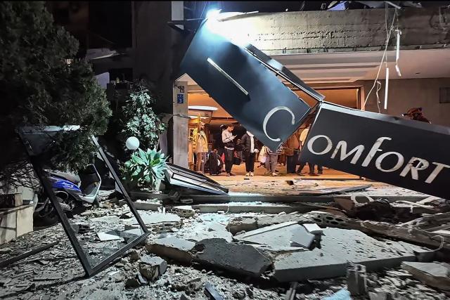This frame grab from AFPTV video footage taken on March 4, 2026 shows people standing at the lobby of Comfort Hotel after it was hit by an Israeli strike in Beirut's eastern suburb of Hazmieh. Israeli strikes hit a Beirut hotel and residential complex in Lebanon's east, Lebanese state media said on March 4, as Israel announced broad strikes in response to Hezbollah missile and drone launches. (Photo by AFPTV / AFP)