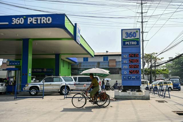 Vehicles queue at a petrol station in Yangon on March 4, 2026. As strikes on Iran moved into a fifth day, observers warned March 4 that the continued choking of crude supplies from the Middle East would continue to push energy prices higher. (Photo by Sai Aung MAIN / AFP)