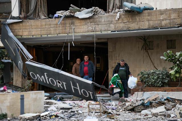 People leave a hotel after it was hit by an Israeli airstrike in Hazmieh, east of Beirut, on March 4, 2026. Israel launched fresh strikes on Iran and Lebanon, where state media reported a residential building was hit on March 4, as Iran's Guards said they had sealed off one of the world's most vital shipping routes for energy. (Photo by IBRAHIM AMRO / AFP)