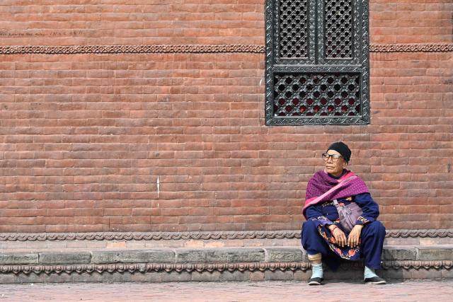 A woman looks on at Durbar Square in Kathmandu on March 4, 2026, a day before Nepal's general election. Nepal set up polling centres on March 4 for one of its most hotly contested elections since the end of civil war in 2006, six months after deadly anti-corruption protests toppled the government. (Photo by TAUSEEF MUSTAFA / AFP)