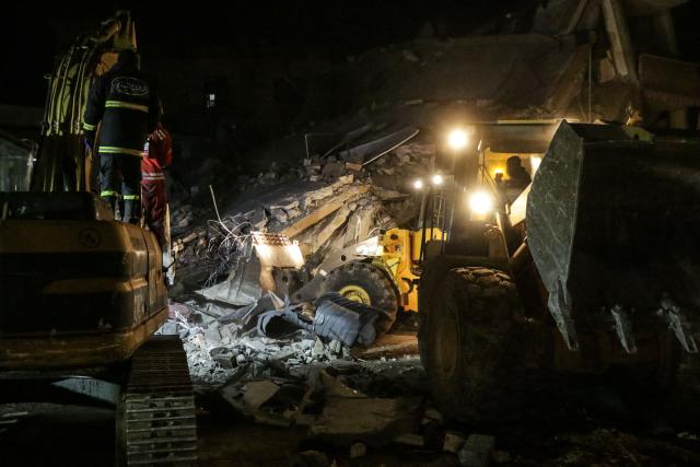 CORRECTION / A bulldozer and an excavator clear rubble as emergency personnel search for victims at the site of an Israeli airstrike that targeted a residential compound in Baalbeck, in Lebanon's Bekaa Valley, early on March 4, 2026. Israel launched fresh strikes on Iran and Lebanon, where state media reported a residential building was hit on March 4, as Iran's Guards said they had sealed off one of the world's most vital shipping routes for energy. (Photo by Nidal SOLH / AFP) / The erroneous mention[s] appearing in the metadata of this photo by Nidal SOLH has been modified in AFP systems in the following manner: [March 4, 2026] instead of [March 4, 2025]. Please immediately remove the erroneous mention[s] from all your online services and delete it (them) from your servers. If you have been authorized by AFP to distribute it (them) to third parties, please ensure that the same actions are carried out by them. Failure to promptly comply with these instructions will entail liability on your part for any continued or post notification usage. Therefore we thank you very much for all your attention and prompt action. We are sorry for the inconvenience this notification may cause and remain at your disposal for any further information you may require.