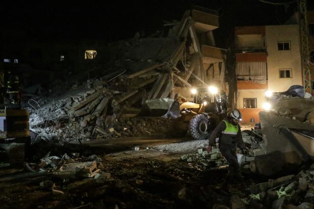 CORRECTION / A bulldozer clears rubble as emergency personnel search for victims at the site of an Israeli airstrike that targeted a residential compound in Baalbeck, in Lebanon's Bekaa Valley, early on March 4, 2026. Israel launched fresh strikes on Iran and Lebanon, where state media reported a residential building was hit on March 4, as Iran's Guards said they had sealed off one of the world's most vital shipping routes for energy. (Photo by Nidal SOLH / AFP) / The erroneous mention[s] appearing in the metadata of this photo by Nidal SOLH has been modified in AFP systems in the following manner: [March 4, 2026] instead of [March 4, 2025]. Please immediately remove the erroneous mention[s] from all your online services and delete it (them) from your servers. If you have been authorized by AFP to distribute it (them) to third parties, please ensure that the same actions are carried out by them. Failure to promptly comply with these instructions will entail liability on your part for any continued or post notification usage. Therefore we thank you very much for all your attention and prompt action. We are sorry for the inconvenience this notification may cause and remain at your disposal for any further information you may require.