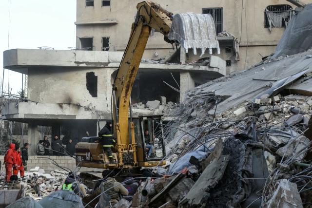 An excavator clears rubble as emergency personnel search for victims at the site of an Israeli airstrike that targeted a residential compound in Baalbeck, in Lebanon's Bekaa Valley, early on March 4, 2026. Israel launched fresh strikes on Iran and Lebanon, where state media reported a residential building was hit on March 4, as Iran's Guards said they had sealed off one of the world's most vital shipping routes for energy. (Photo by Nidal SOLH / AFP)