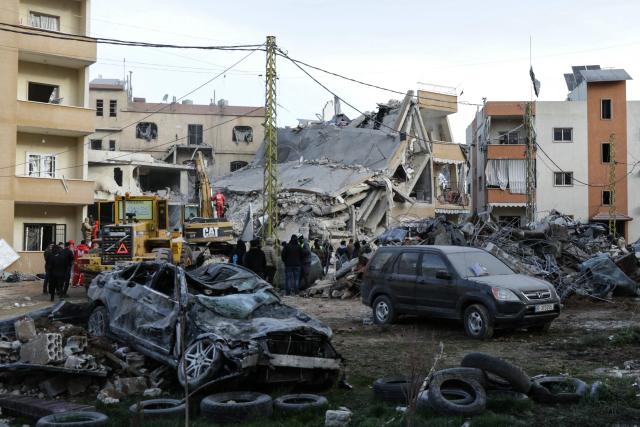 A bulldozer and an excavator clear rubble as emergency personnel search for victims at the site of an Israeli airstrike that targeted a residential compound in Baalbeck, in Lebanon's Bekaa Valley, early on March 4, 2026. Israel launched fresh strikes on Iran and Lebanon, where state media reported a residential building was hit on March 4, as Iran's Guards said they had sealed off one of the world's most vital shipping routes for energy. (Photo by Nidal SOLH / AFP)