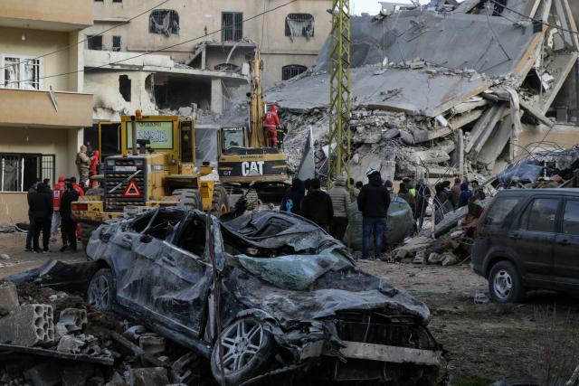A bulldozer and an excavator clear rubble as emergency personnel search for victims at the site of an Israeli airstrike that targeted a residential compound in Baalbeck, in Lebanon's Bekaa Valley, early on March 4, 2026. Israel launched fresh strikes on Iran and Lebanon, where state media reported a residential building was hit on March 4, as Iran's Guards said they had sealed off one of the world's most vital shipping routes for energy. (Photo by Nidal SOLH / AFP)