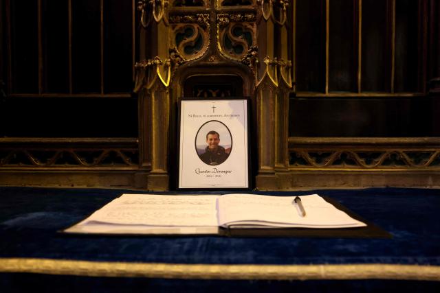 (FILES) This photograph shows a guestbook for the faithful to leave a message in tribute to Quentin Deranque at the end of a mass at the Saint Georges church in tribute to Quentin Deranque, who died after being attacked on the sidelines of a far-right protest against a La France Insoumise (LFI) event at Sciences Po Lyon, in Lyon on February 21, 2026. Two men suspected of having taken part in the violence against radical far-right activist Quentin Deranque in Lyon were arrested on March 4, 2026, two weeks after a first wave of arrests, police sources told AFP. (Photo by Alex MARTIN / AFP)
