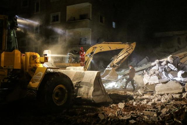 A bulldozer and an excavator clear rubble as emergency personnel search for victims at the site of an Israeli airstrike that targeted a residential compound in Baalbeck, in Lebanon's Bekaa Valley, early on March 4, 2026. Israel launched fresh strikes on Iran and Lebanon, where state media reported a residential building was hit on March 4, as Iran's Guards said they had sealed off one of the world's most vital shipping routes for energy. (Photo by Nidal SOLH / AFP)