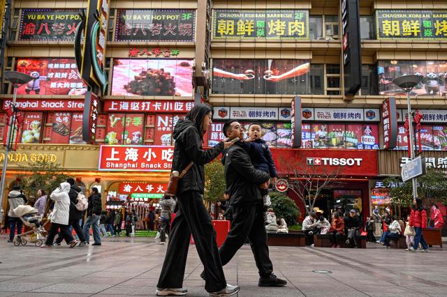People walk on the Nanjing Road Pedestrian Street in Shanghai on March 4, 2026. (Photo by Jade GAO / AFP)