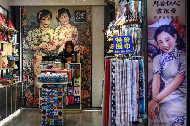 A vendor waits for customers at a souvenir shop on the Nanjing Road Pedestrian Street in Shanghai on March 4, 2026. (Photo by Jade GAO / AFP)