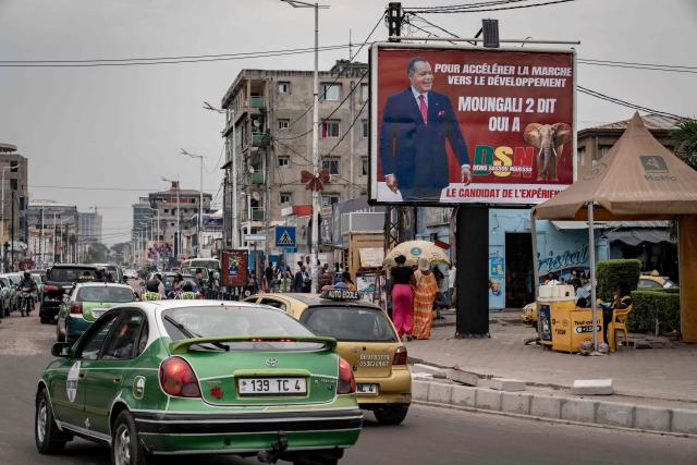 TOPSHOT - Vehicles drive past an electoral poster of Congo-Brazzaville's 82-year-old President Denis Sassou Nguesso in Brazzaville on March 3, 2026, ahead of the country's March 15 presidential election. Congo-Brazzaville, a former French colony which gained independence in 1960, is rich in oil but nearly half of its six million people live below the poverty line. (Photo by Glody MURHABAZI / AFP)