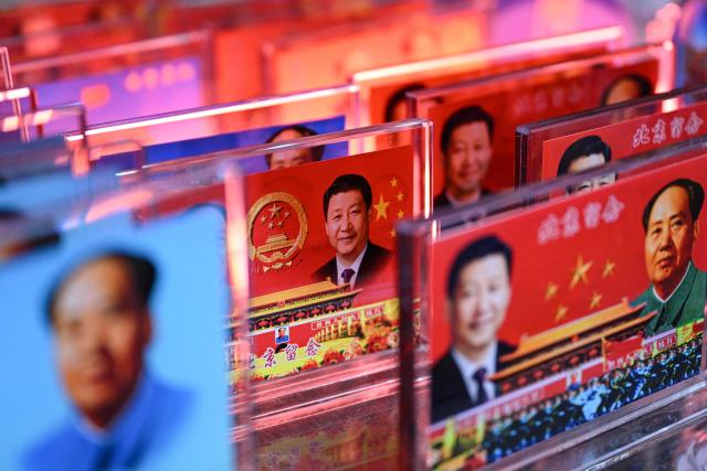 Portraits of China's President Xi Jinping and late communist leader Mao Zedong are seen at a souvenir shop in a tourist area of Beijing on March 4, 2026. (Photo by Pedro PARDO / AFP)