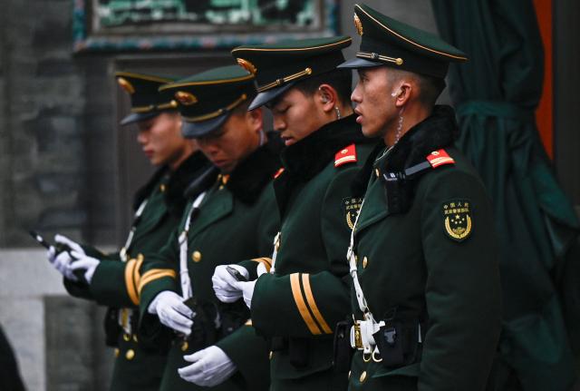 Chinese paramilitary policemen stand guard in a street surrounding the Great Hall of the People where the opening of the Chinese People's Political Consultative Conference (CPPCC) takes place, in Beijing on March 4, 2026. (Photo by Pedro PARDO / AFP)