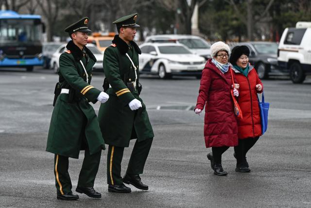 Chinese paramilitary policemen patrol in a street surrounding the Great Hall of the People where the opening of the Chinese People's Political Consultative Conference (CPPCC) takes place, in Beijing on March 4, 2026. (Photo by Pedro PARDO / AFP)