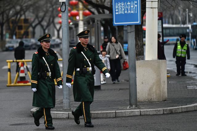 Chinese paramilitary policemen patrol a street surrounding the Great Hall of the People where the opening of the Chinese People's Political Consultative Conference (CPPCC) takes place, in Beijing on March 4, 2026. (Photo by Pedro PARDO / AFP)