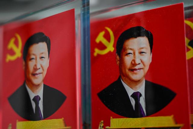 Portraits of China's President Xi Jinping are seen at a souvenir shop in a tourist area of Beijing on March 4, 2026. (Photo by Pedro PARDO / AFP)
