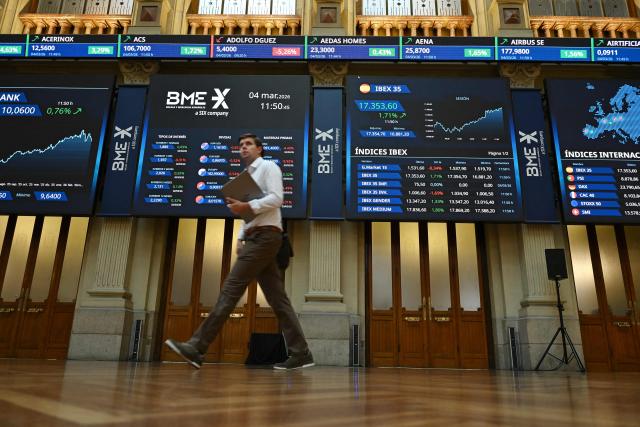 A person walks past at the Madrid Stock Exchange in Madrid on March 4, 2026. Markets were down sharply across the world following the weekend U.S. and Israeli attacks on Iran, with oil prices rising. (Photo by JAVIER SORIANO / AFP)