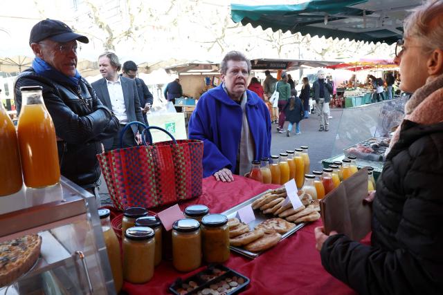 Socialist Party (PS)'s Strasbourg mayoral candidate Catherine Trautmann listens to a vendor during her visit to a local market ahead of France's upcoming municipal elections in Strasbourg, eastern France on March 4, 2026. (Photo by FREDERICK FLORIN / AFP)