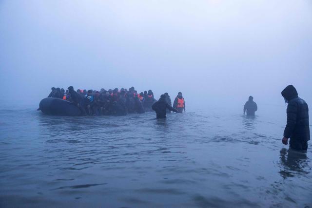 TOPSHOT - Smugglers assist migrants to board a boat in an attempt to cross the English Channel off the beach of Gravelines, northern France, on March 4, 2026. (Photo by Sameer Al-DOUMY / AFP)