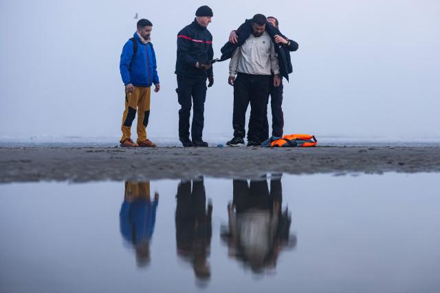 French firefighters help a migrant who failed to board a smugglers' boat in an attempt to cross the English Channel off the beach of Gravelines, northern France, on March 4, 2026. (Photo by Sameer Al-DOUMY / AFP)