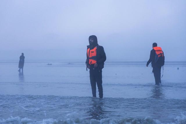 Migrants try to board a smugglers' boat in an attempt to cross the English Channel off the beach of Gravelines, northern France, on March 4, 2026. (Photo by Sameer Al-DOUMY / AFP)
