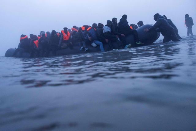Smugglers assist migrants to board a boat in an attempt to cross the English Channel off the beach of Gravelines, northern France, on March 4, 2026. (Photo by Sameer Al-DOUMY / AFP)