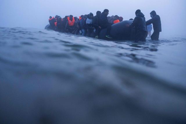 Smugglers assist migrants to board a boat in an attempt to cross the English Channel off the beach of Gravelines, northern France, on March 4, 2026. (Photo by Sameer Al-DOUMY / AFP)