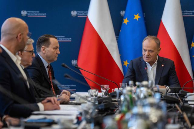 Poland's Prime Minister Donald Tusk (R) and Deputy Prime Minister and Minister of foreign Afairs Radoslaw Sikorski (2nd R) take part in a meeting of a Coordinating Committee on the Situation in the Middle East at Polish Foreign Afairs Ministry building in Warsaw on March 4, 2026. (Photo by Wojtek RADWANSKI / AFP)