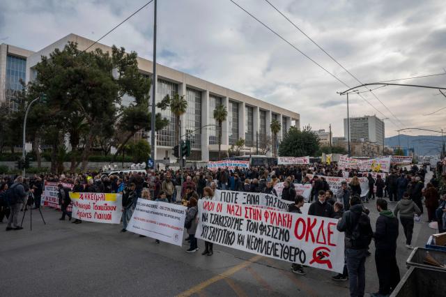 Protesters march behind a banner during an antifascist demonstration outside of the Greek court of appeal during the trial of far-right party Golden Dawn. A Greek appeals court on March 4, 2026 convicted senior officials in the neo-Nazi Golden Dawn party for "belonging to and running a criminal organisation" in a landmark trial. (Photo by Aggelos NAKKAS / AFP)