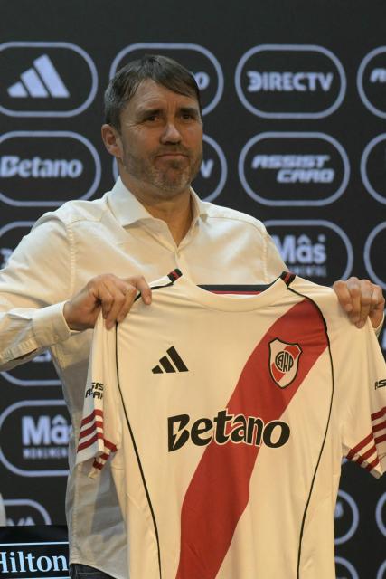 Eduardo Coudet, Argentina's football side Rive Plate new head coach, poses for pictures holding a shirt during his presentation at the Mas Monumental stadium in Buenos Aires on March 4, 2026. (Photo by JUAN MABROMATA / AFP)