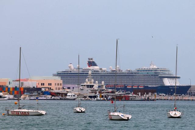 A cruise ship is seen anchored at the old port of Doha on March 4, 2026. As the Iran-US conflict rages across the Middle East, a total of six cruise ships carrying some 15,000 passengers and over 6000 crew remain stalled in port with guests onboard in Dubai and Qatar. (Photo by Karim JAAFAR / AFP)