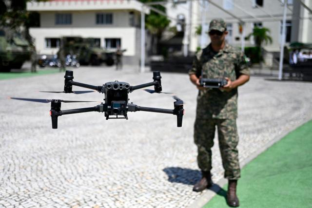 A Marine Corps officer flies a drone during a press visit to the General Command Headquarters of the Brazilian Marine Corps (Corpo de Fuzileiros Navais) at Ilha das Cobras, within Guanabara Bay, in Rio de Janeiro, Brazil, on March 4, 2026. (Photo by MAURO PIMENTEL / AFP)