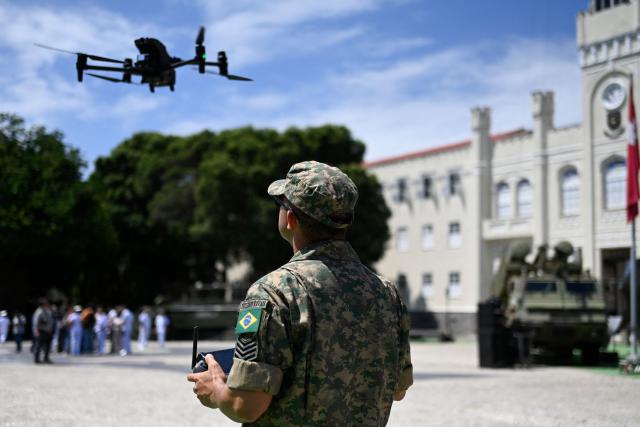A Marine Corps officer flies a drone during a press visit to the General Command Headquarters of the Brazilian Marine Corps (Corpo de Fuzileiros Navais) at Ilha das Cobras, within Guanabara Bay, in Rio de Janeiro, Brazil, on March 4, 2026. (Photo by MAURO PIMENTEL / AFP)