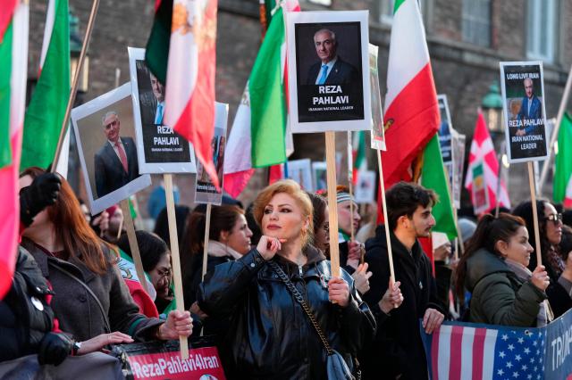 Protesters hold placards featuring Reza Pahlavi, Iran's former crown prince and now key opposition figure, during a demonstration for a free Iran in the Parliament Courtyard at Christiansborg in Copenhagen on March 4, 2026. (Photo by Liselotte Sabroe / Ritzau Scanpix / AFP) / Denmark OUT