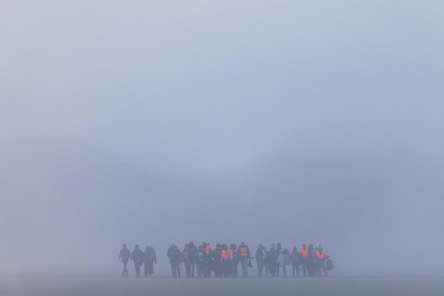 Migrants arrive in a foggy weather to try to board a smugglers' boat in an attempt to cross the English Channel off the beach of Gravelines, northern France, on March 4, 2026. (Photo by Sameer Al-DOUMY / AFP)