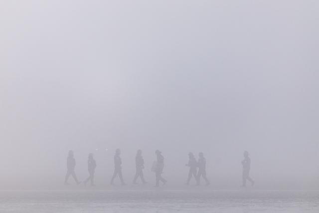 French police officers patrol the beach in a foggy weather to prevent migrants from crossing the English Channel off the beach of Gravelines, northern France, on March 4, 2026. (Photo by Sameer Al-DOUMY / AFP)