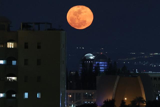 TOPSHOT - The waning gibbous moon rises over Tel Aviv after sunset on March 4, 2026. (Photo by Jack GUEZ / AFP)