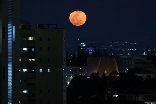 The waning gibbous moon rises over Tel Aviv after sunset on March 4, 2026. (Photo by Jack GUEZ / AFP)