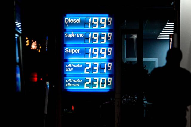 A man passes an illuminated display showing the prices at a gas station in Berlin on March 4, 2026. Oil prices are expected to rise after traffic through the Strait of Hormuz has almost entirely halted following Iran's threat to attack ships that would try to sail through. (Photo by Tobias SCHWARZ / AFP)