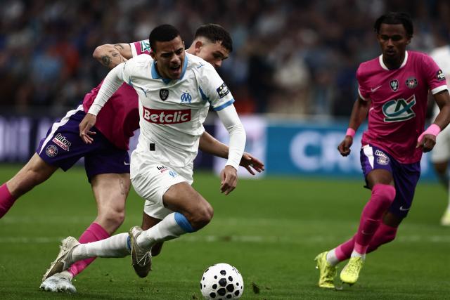 Marseille's English forward #10 Mason Greenwood is tackled during the French Cup quarter final football match between Olympique de Marseille (OM) and Toulouse FC at the Stade Velodrome stadium in Marseille, southern France on March 4, 2026. (Photo by Thibaud MORITZ / AFP)