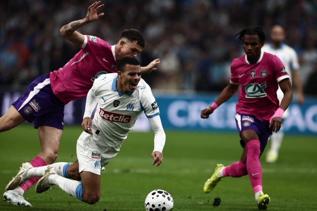 Marseille's English forward #10 Mason Greenwood is tackled during the French Cup quarter final football match between Olympique de Marseille (OM) and Toulouse FC at the Stade Velodrome stadium in Marseille, southern France on March 4, 2026. (Photo by Thibaud MORITZ / AFP)