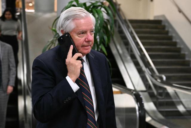 US Senator Lindsey Graham (R-SC) speaks on the phone on Capitol Hill in Washington, DC, on March 4, 2026. The US Senate is set to vote on March 4 on a resolution aimed at curbing President Donald Trump's authority to continue military strikes on Iran, in the first congressional test of support for a conflict launched without explicit approval from lawmakers. (Photo by Jim WATSON / AFP)