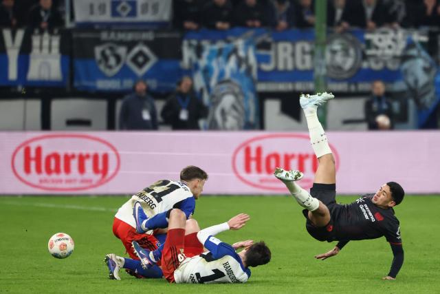 Bayer Leverkusen's Argentinian midfielder #06 Ezequiel Fernandez (R) ends up in the air next to Hamburg's German midfielder #21 Nicolai Remberg (L) and Hamburg's Georgian defender #16 Giorgi Gocholeishvili during the German first division Bundesliga football match between Hamburger SV and Bayer 04 Leverkusen in Hamburg, northern Germany on March 4, 2026. (Photo by IBRAHIM OT / AFP) / DFL REGULATIONS PROHIBIT ANY USE OF PHOTOGRAPHS AS IMAGE SEQUENCES AND/OR QUASI-VIDEO
