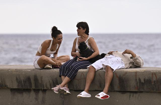 People gather after a blackout at the Malecon in Havana on March 4, 2026. (Photo by ADALBERTO ROQUE / AFP)
