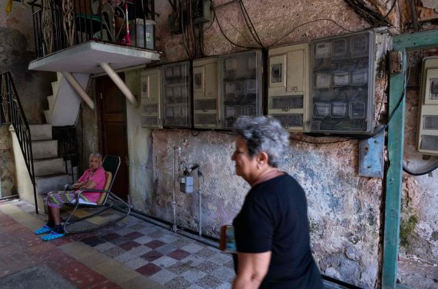 A woman sits outside her home after a blackout in Havana on March 4, 2026. (Photo by Yamil LAGE / AFP)